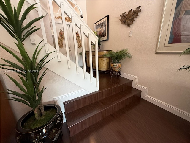 stairway featuring baseboards and wood finished floors