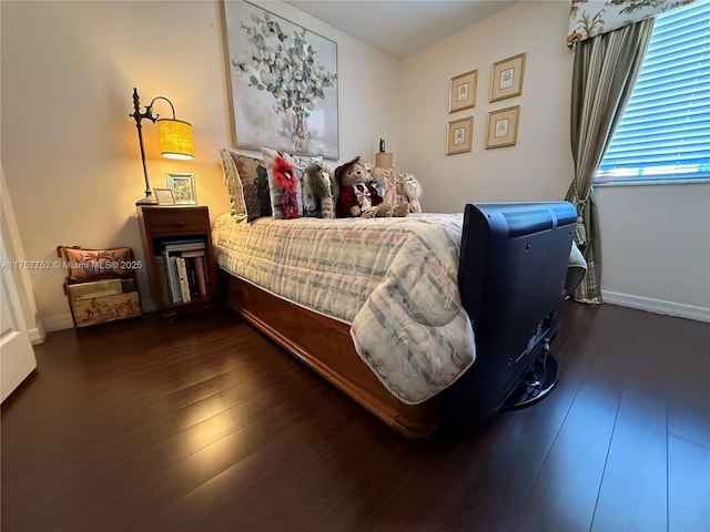 bedroom with wood finished floors and baseboards