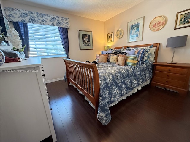 bedroom with wood-type flooring, a textured ceiling, and baseboards