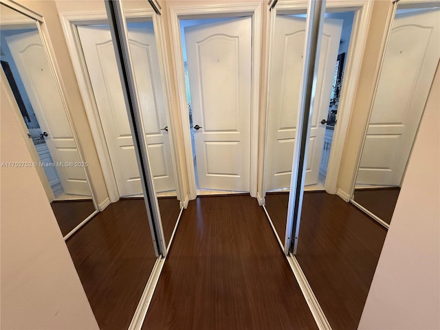 corridor featuring dark wood-style flooring