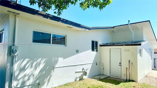 view of side of property with an outdoor structure and stucco siding
