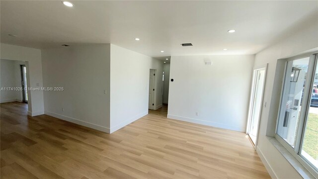empty room with light wood-style floors, baseboards, and recessed lighting