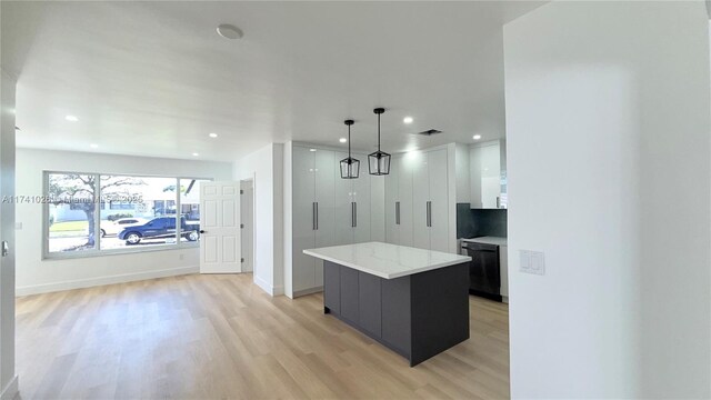 kitchen featuring light wood-style flooring, recessed lighting, a kitchen island, baseboards, and dishwasher