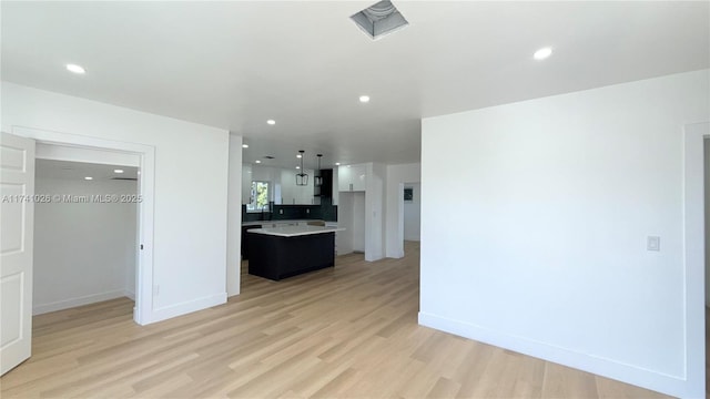 kitchen featuring a center island, recessed lighting, light countertops, light wood-style floors, and extractor fan