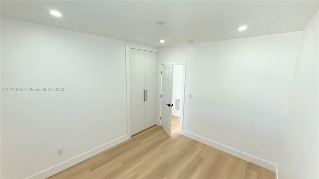 empty room with light wood finished floors, baseboards, and recessed lighting