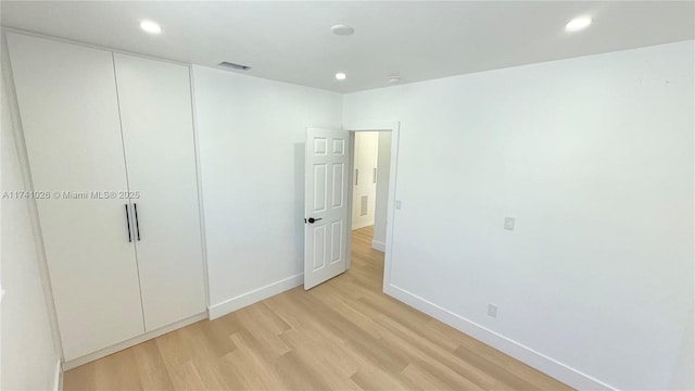 unfurnished bedroom featuring recessed lighting, visible vents, baseboards, a closet, and light wood finished floors