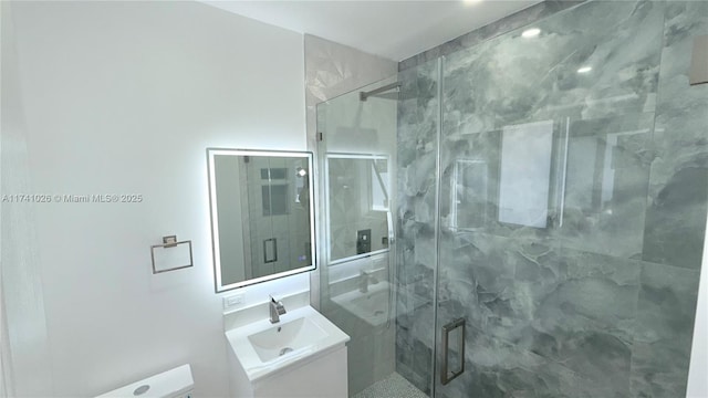 bathroom with a marble finish shower and vanity
