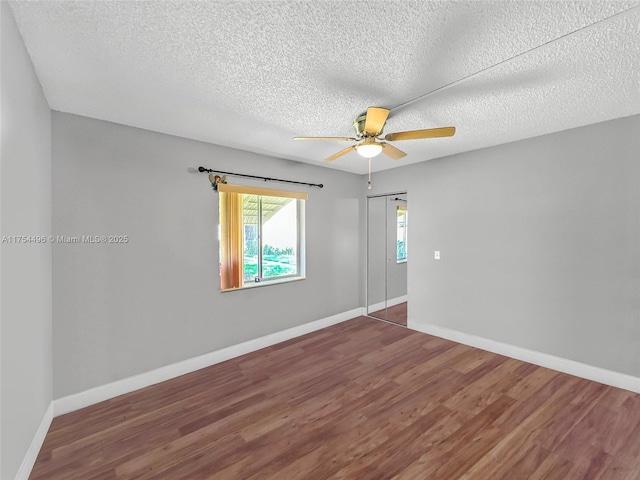 unfurnished room featuring a ceiling fan, a textured ceiling, baseboards, and wood finished floors