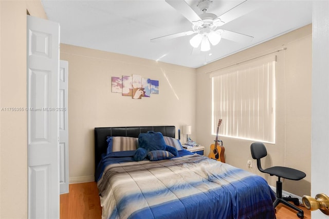 bedroom with baseboards, a ceiling fan, and wood finished floors