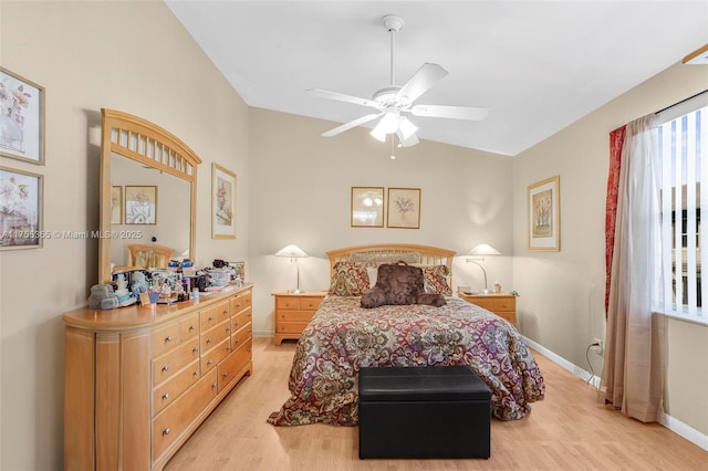 bedroom featuring light wood finished floors, a ceiling fan, and baseboards