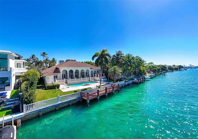 dock area with a fenced in pool, fence, a yard, and a water view