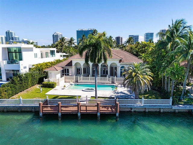 back of house with a fenced backyard, a patio, and a water view