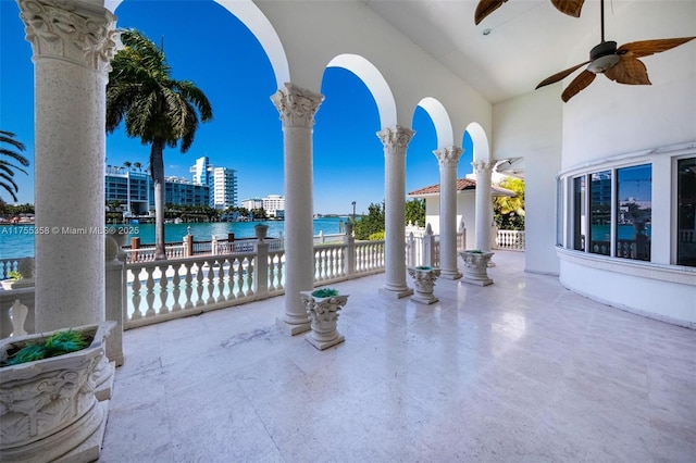 view of patio featuring a water view and ceiling fan