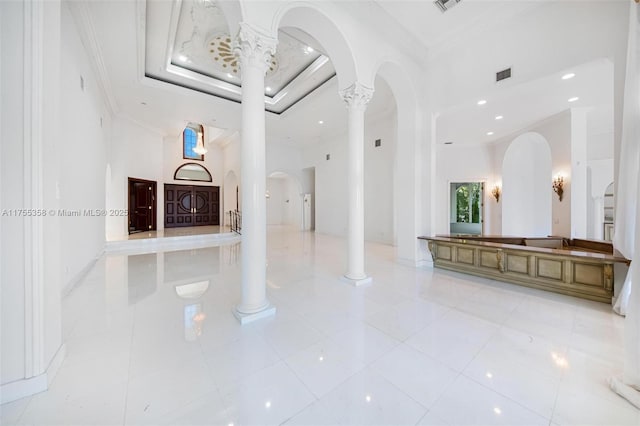 interior space featuring crown molding, decorative columns, visible vents, and a raised ceiling