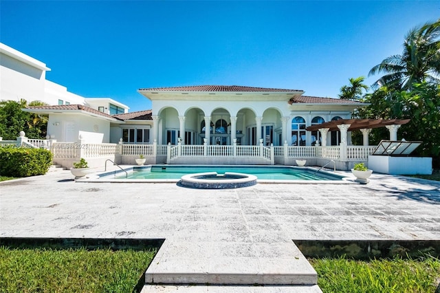 rear view of house with fence, a hot tub, a community pool, a tile roof, and a patio area