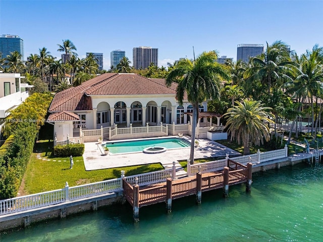 rear view of property featuring a patio, a yard, a fenced backyard, a water view, and a tile roof