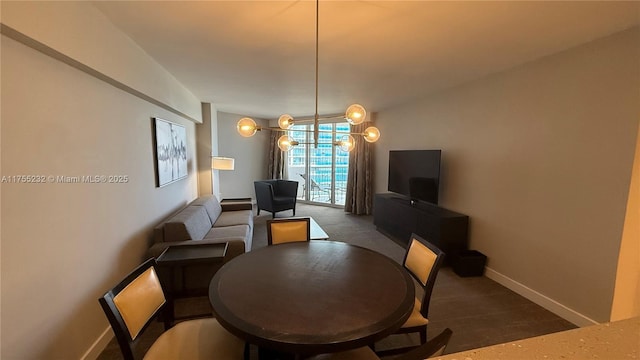 dining space featuring an inviting chandelier, wood finished floors, and baseboards