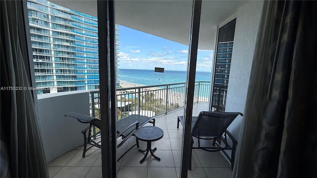 balcony featuring a view of the beach and a water view