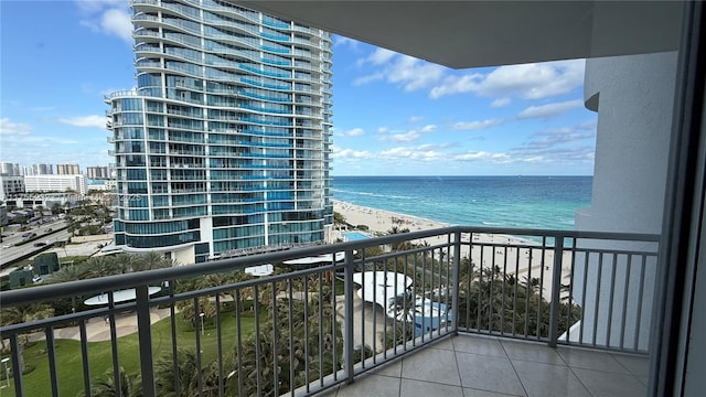 balcony with a view of the beach, a water view, and a city view