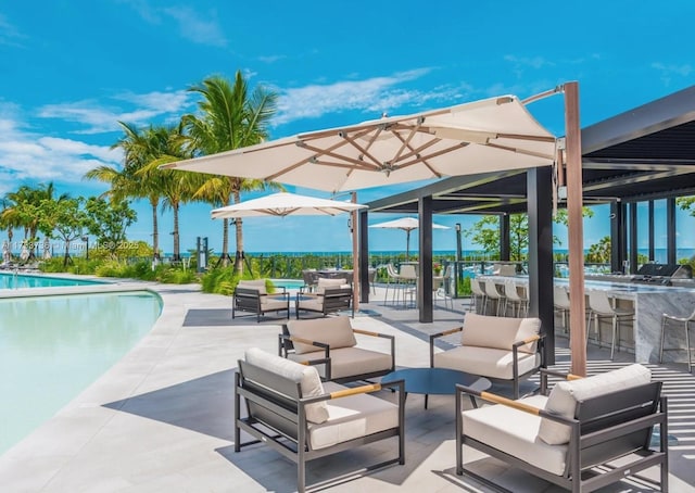 view of patio featuring outdoor dry bar, an outdoor living space, and a community pool