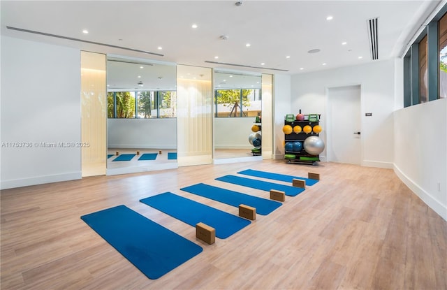 workout area with recessed lighting, baseboards, and wood finished floors