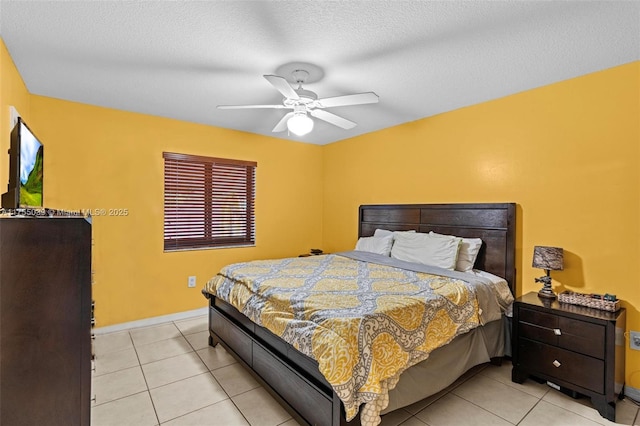 bedroom featuring a textured ceiling, ceiling fan, light tile patterned flooring, and baseboards