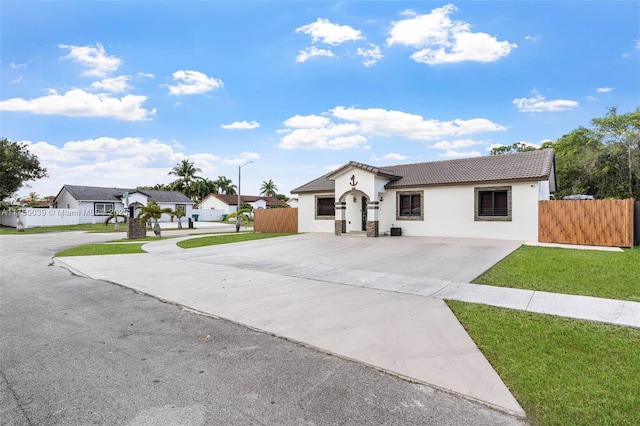 view of front of home with concrete driveway, a tile roof, and fence