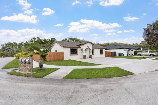 view of front facade with concrete driveway, fence, and stucco siding