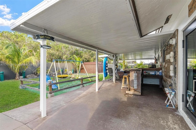 view of patio featuring fence and a playground