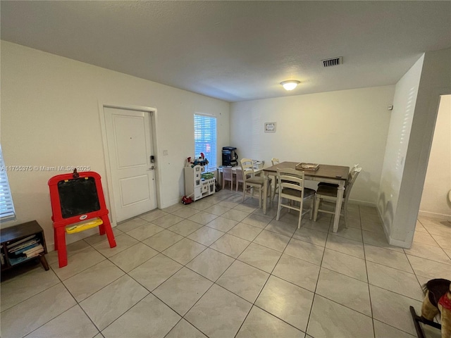 dining room featuring light tile patterned flooring, visible vents, and baseboards