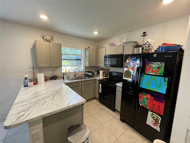 kitchen with light tile patterned floors, gray cabinetry, a peninsula, a sink, and black appliances