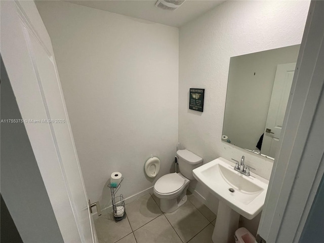 bathroom with tile patterned flooring, toilet, a sink, visible vents, and baseboards