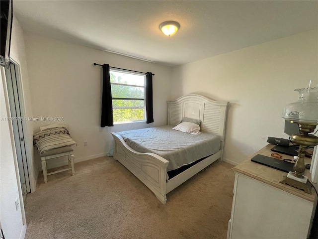 bedroom featuring light carpet and baseboards