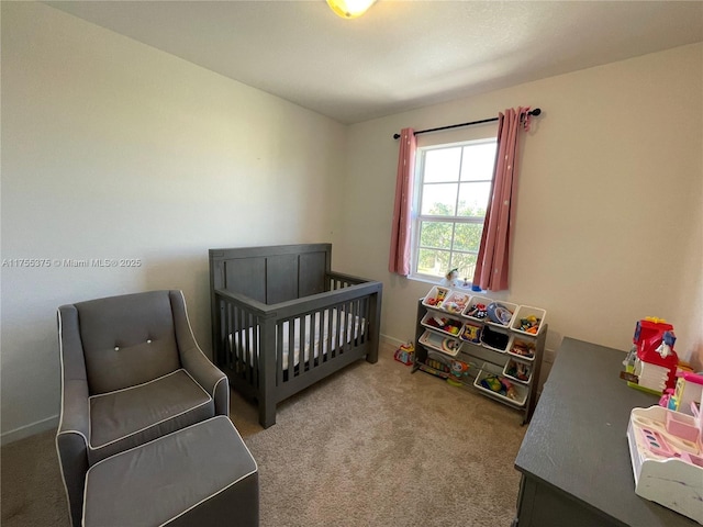 carpeted bedroom featuring a nursery area