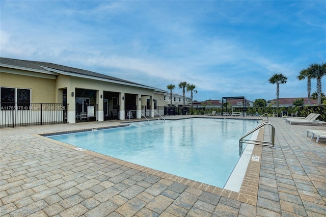 community pool featuring a patio and fence