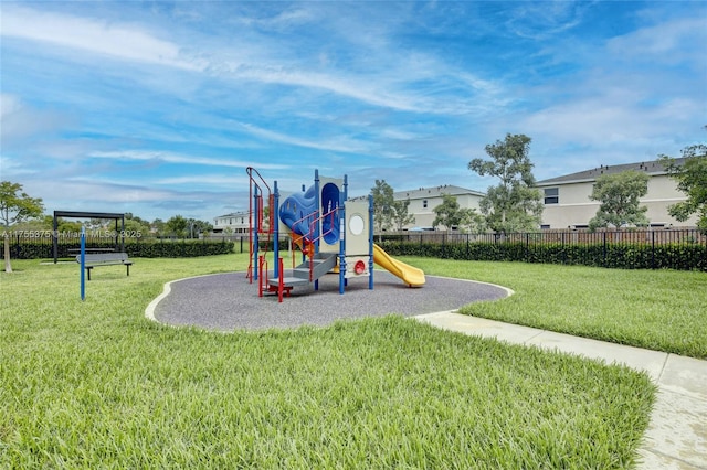 community jungle gym featuring a lawn and fence