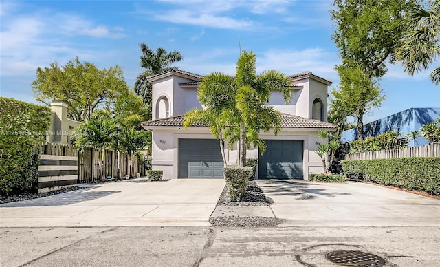 view of front of home featuring driveway, fence, and stucco siding