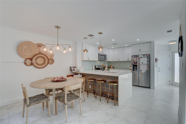 unfurnished dining area with baseboards, visible vents, a sink, and recessed lighting