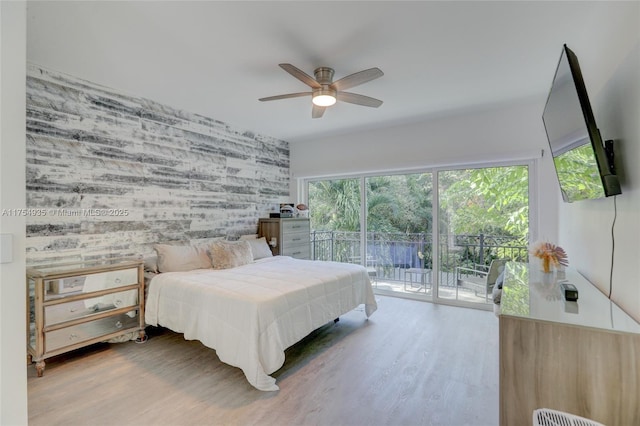 bedroom featuring wallpapered walls, access to outside, a ceiling fan, and wood finished floors