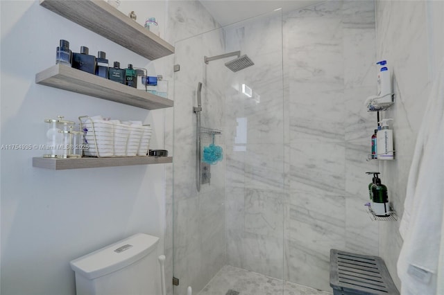 full bath featuring toilet and a marble finish shower