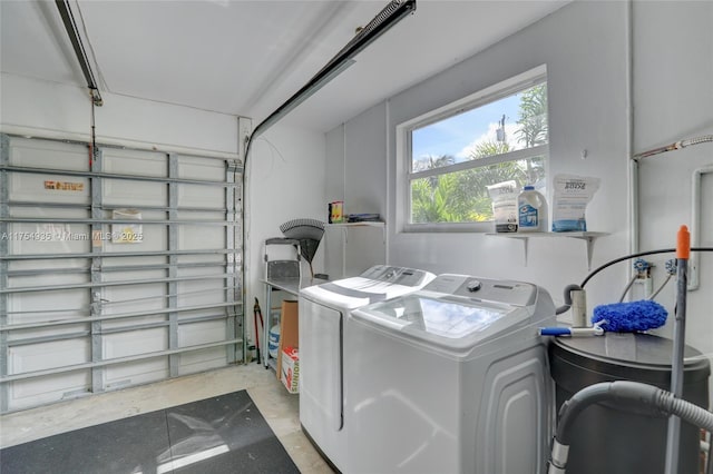 clothes washing area featuring a garage and washing machine and clothes dryer