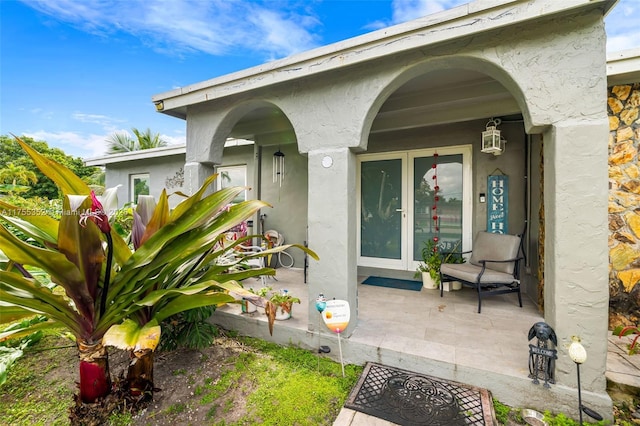 property entrance with french doors and stucco siding