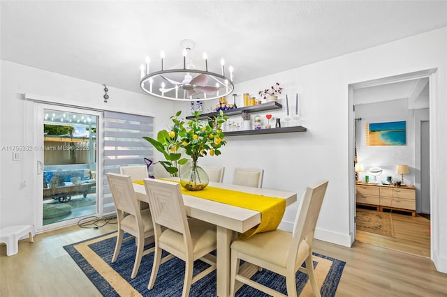 dining space with baseboards, an inviting chandelier, and light wood-style floors