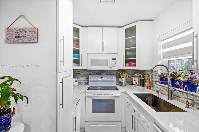 kitchen featuring light countertops, white appliances, white cabinets, and a sink
