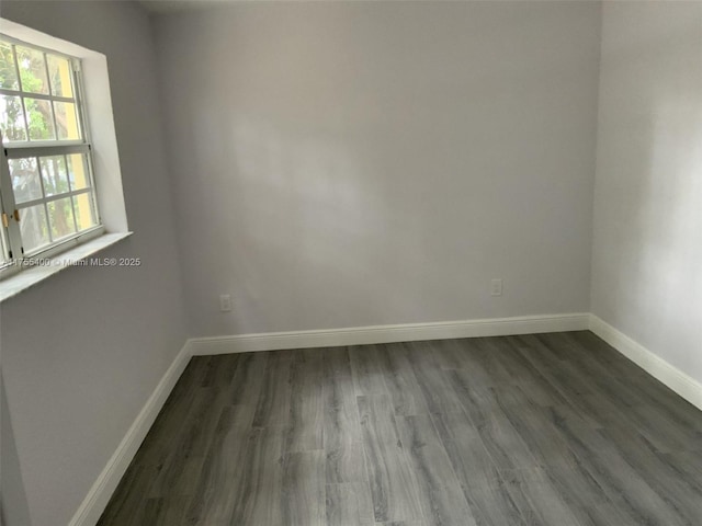 unfurnished room featuring dark wood finished floors and baseboards