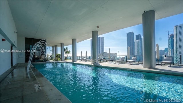 pool with a patio area and a city view