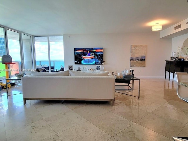 living area featuring floor to ceiling windows, visible vents, and baseboards