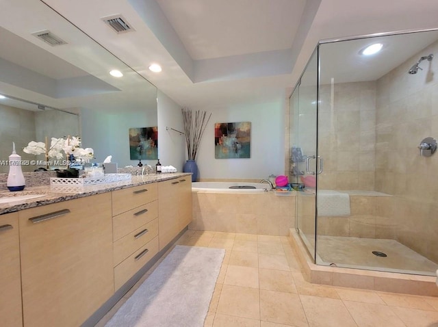 bathroom featuring a tray ceiling, visible vents, a garden tub, and a shower stall