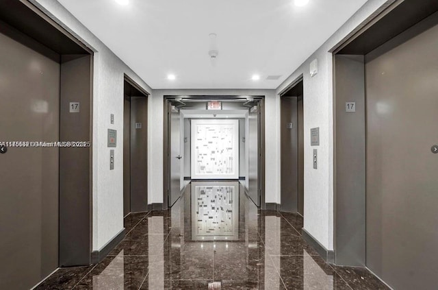 hall featuring elevator and baseboards