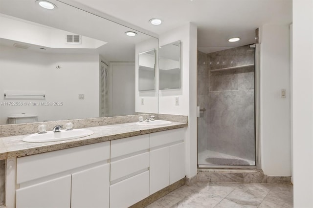 bathroom featuring double vanity, a sink, visible vents, and a shower stall